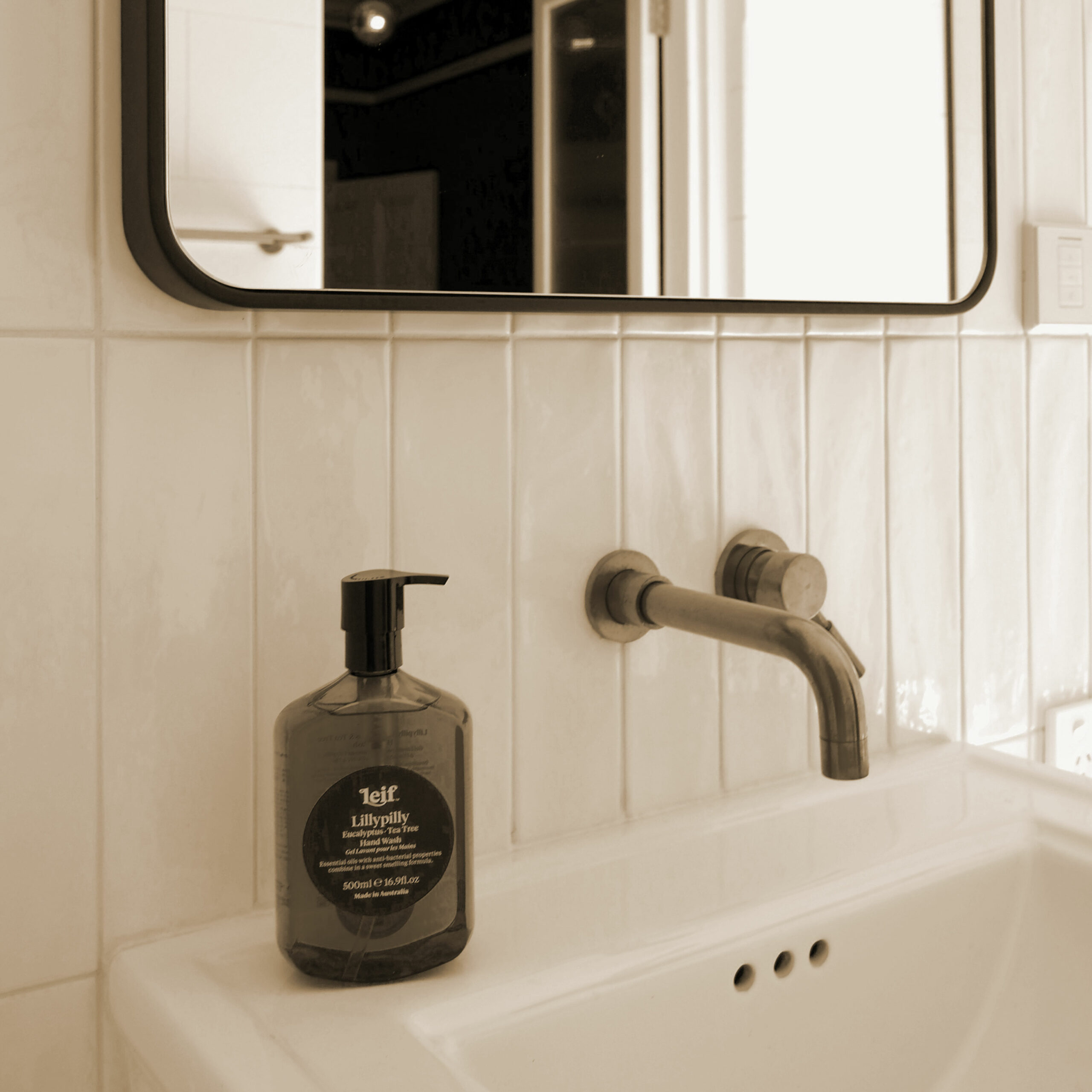 Lavabo hôtel haut de gamme avec flacon de savon liquide premium et robinetterie murale design, mise en place housekeeping soignée par le Groupe St Ho