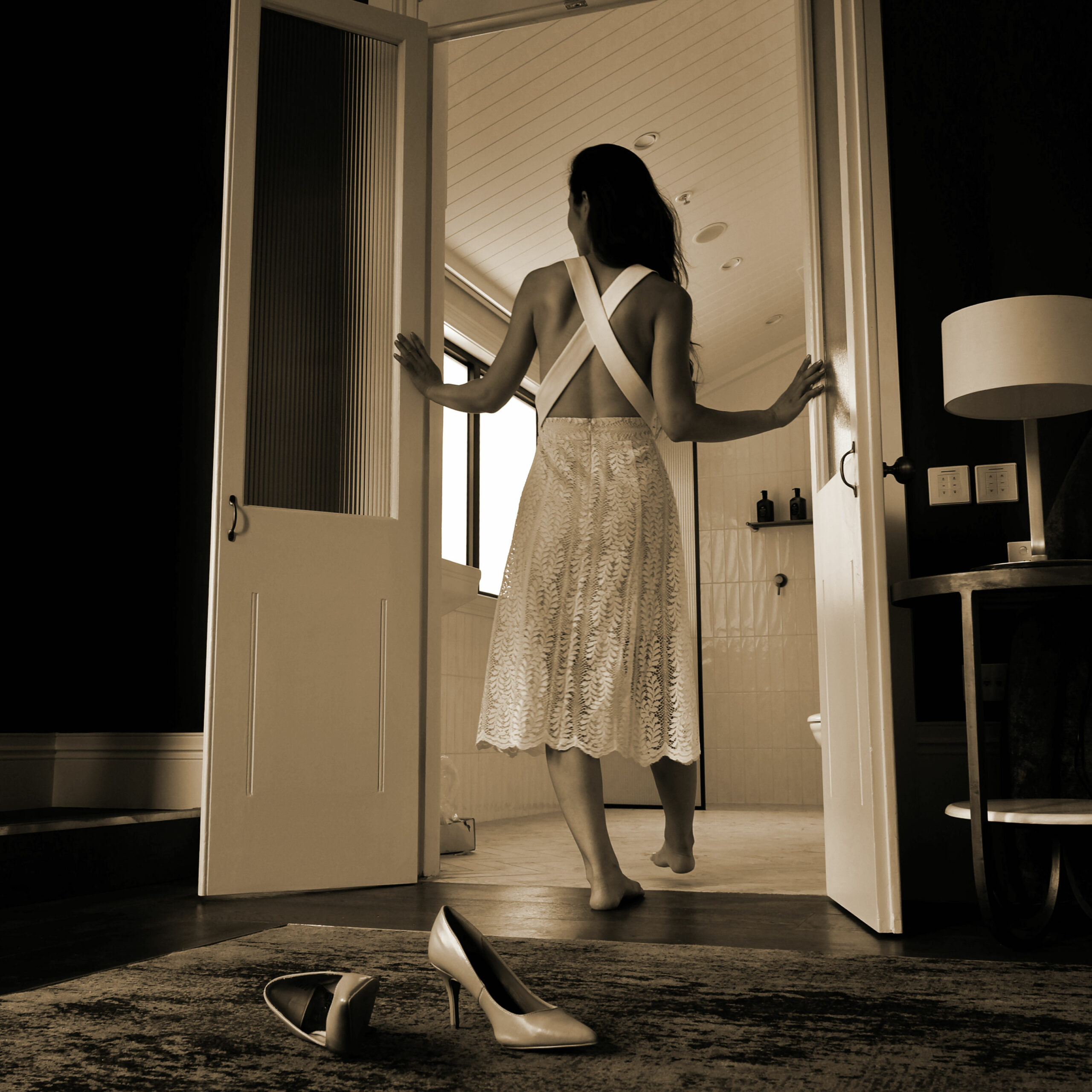 Cliente en robe blanche élégante découvrant sa chambre d'hôtel haut de gamme, symbole d'une expérience client sublimée par un housekeeping d'excellence